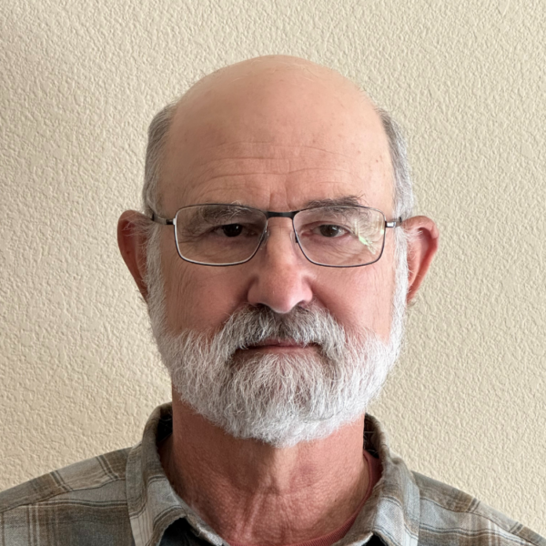 Headshot of man with glasses and a neutral facial expression